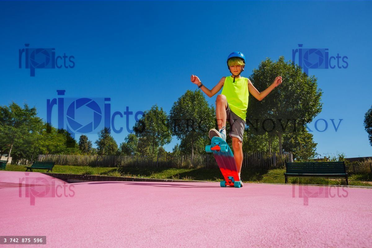 Young boy skate his skateboard at skatepark pose on ramp