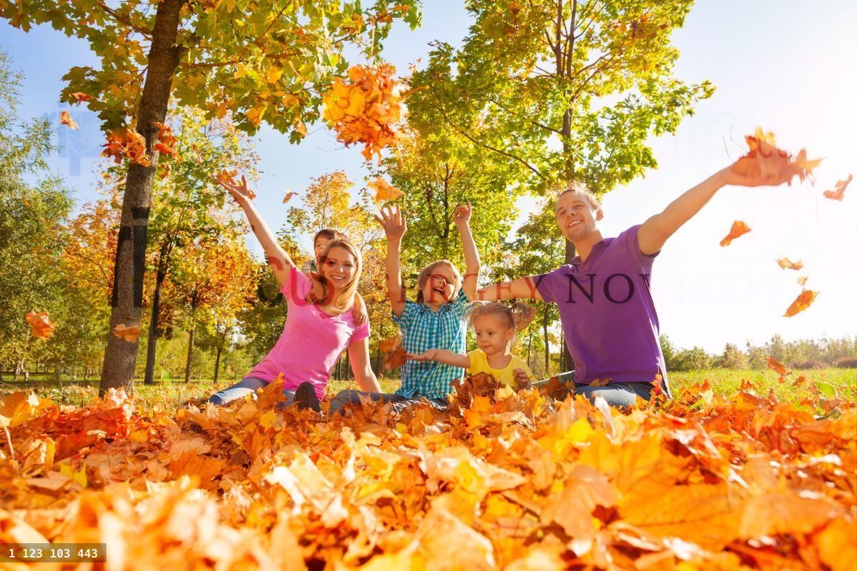 Family throwing and play with leaves while sitting