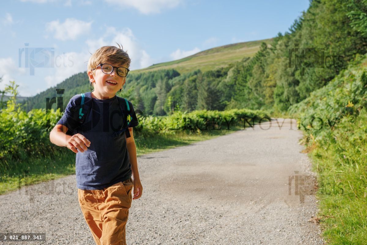 Young boy happily explores nature on a bright day