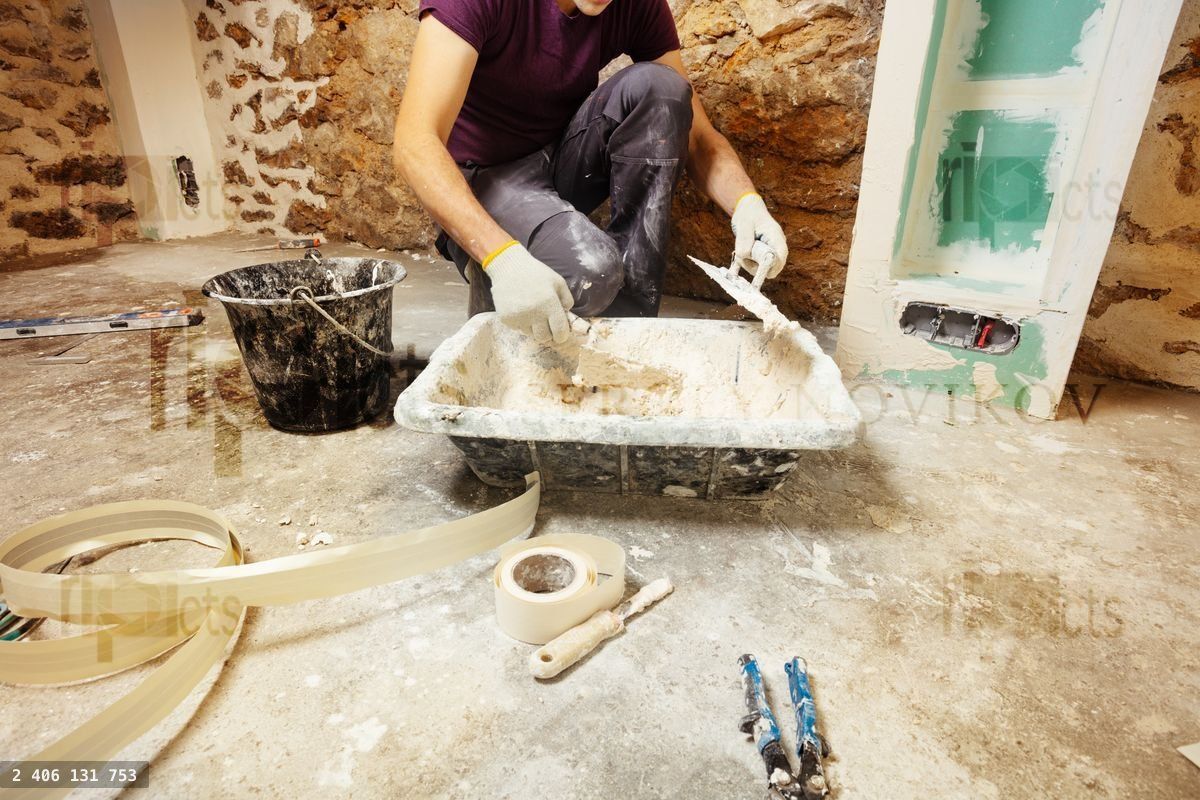 Young man mixing plaster to put on drywall at home renovation