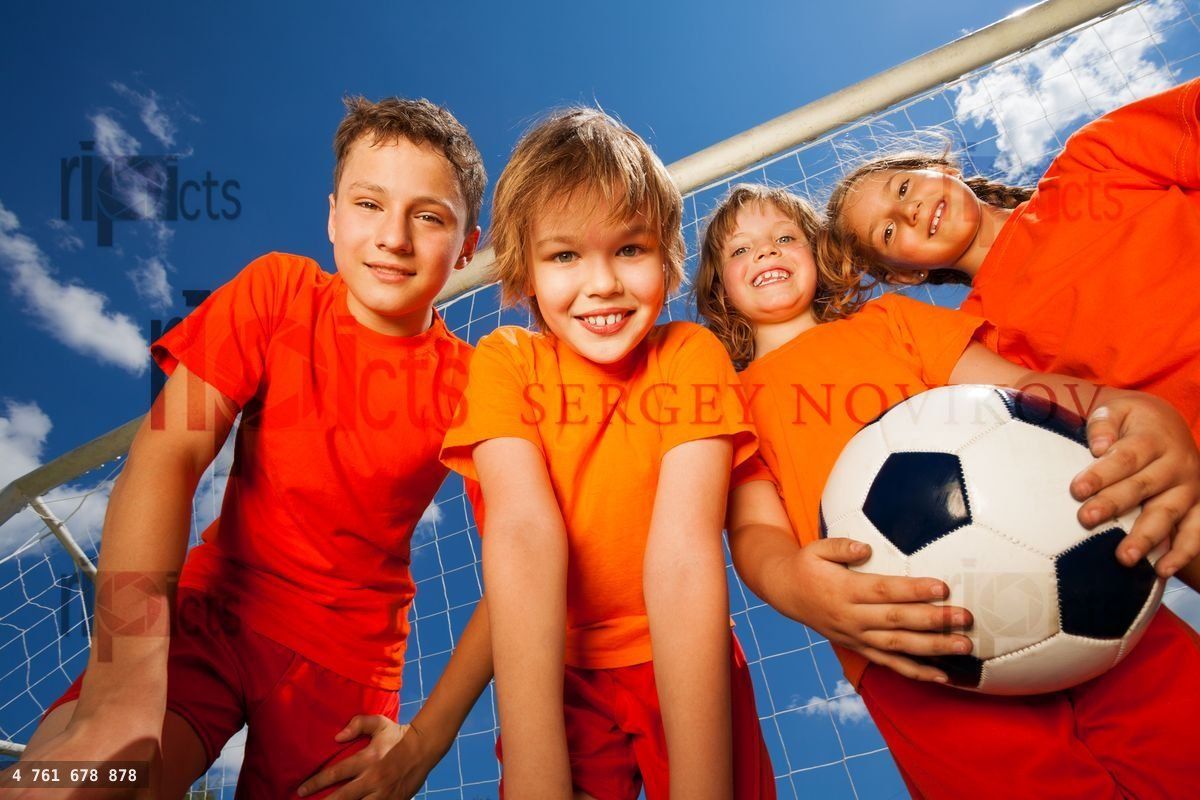 Four happy kids with football portrait