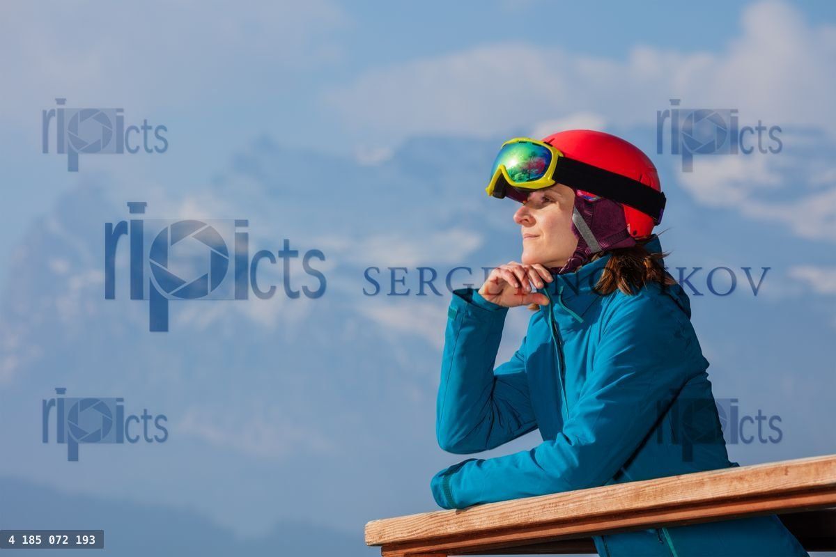 Woman in ski gear admires Alps from chalet