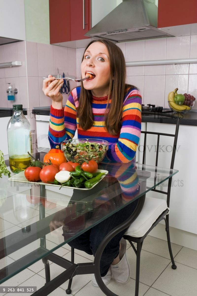 Woman eating salad on the kitchen