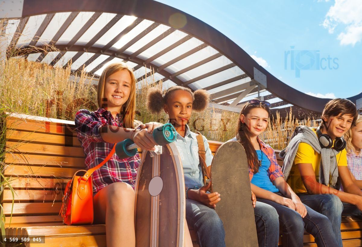 View of children who sit on wooden bench together