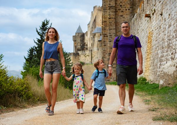 Tourists parents with kids enjoy walk along ancient castle walls