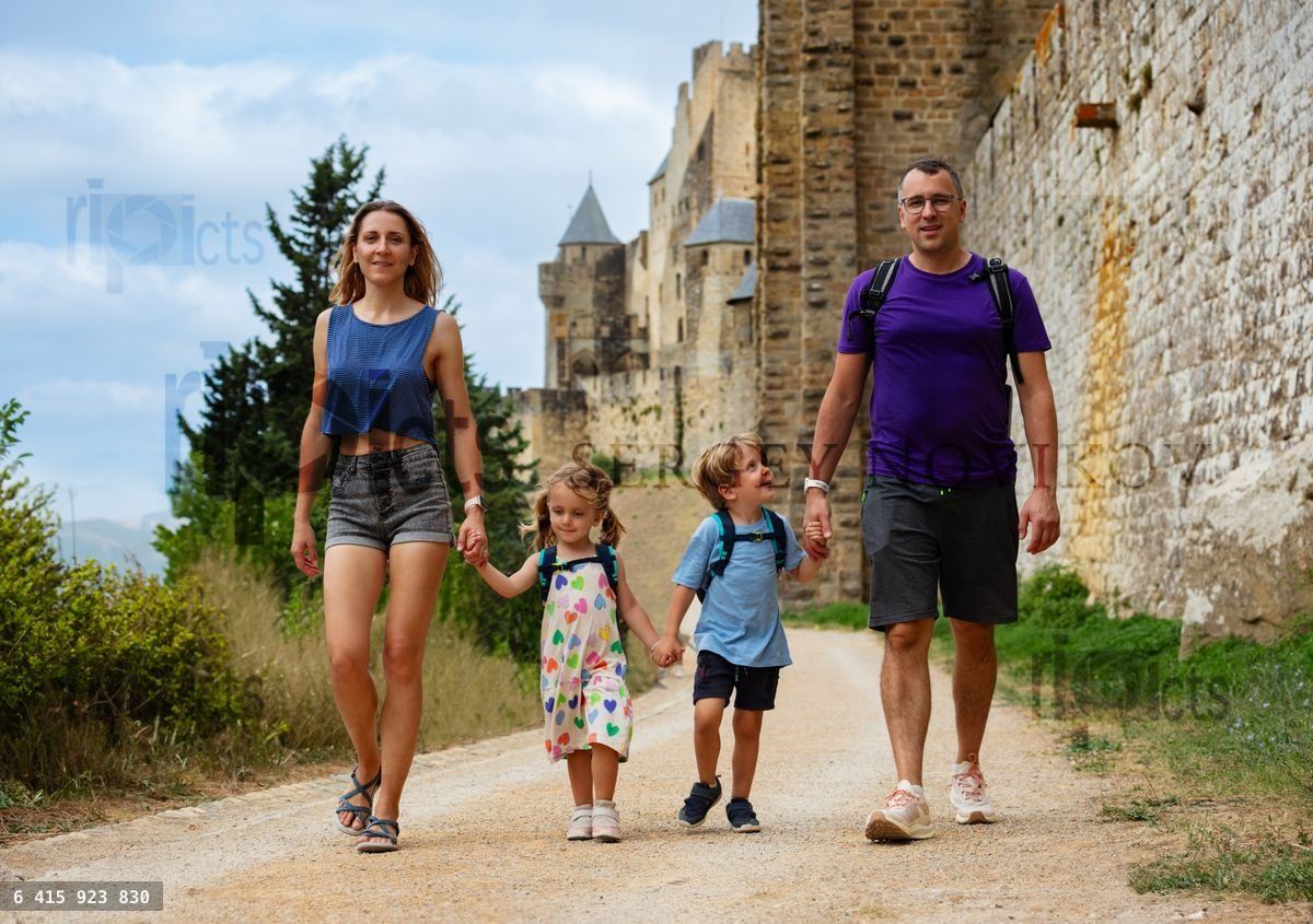 Tourists parents with kids enjoy walk along ancient castle walls