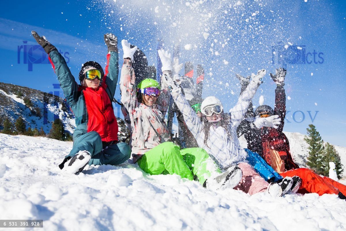 friends with snowboards throwing snow