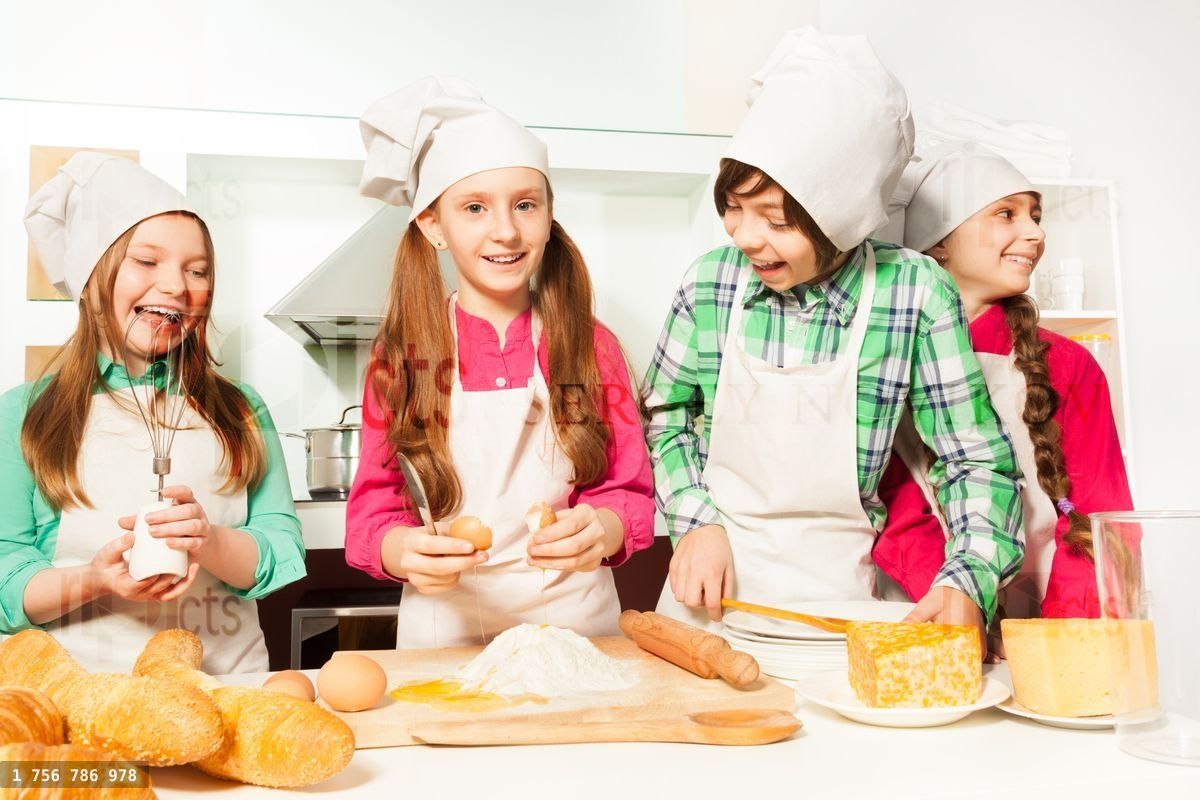 Four happy young cooks making dough bakery