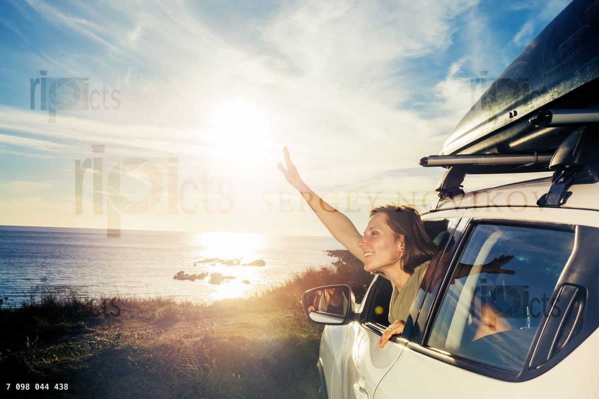 Woman smile look from car window on ocean sunset and wave hand