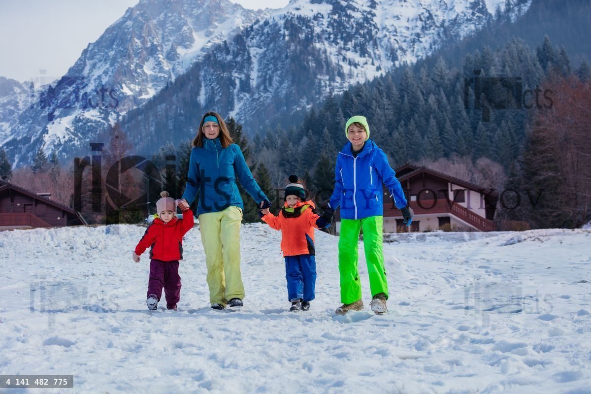 Family with kids enjoy snowy mountain vacation walk in forest
