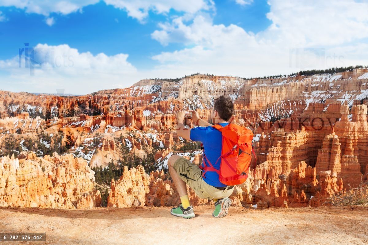 Yong man take picture of Bryce canyon with phone