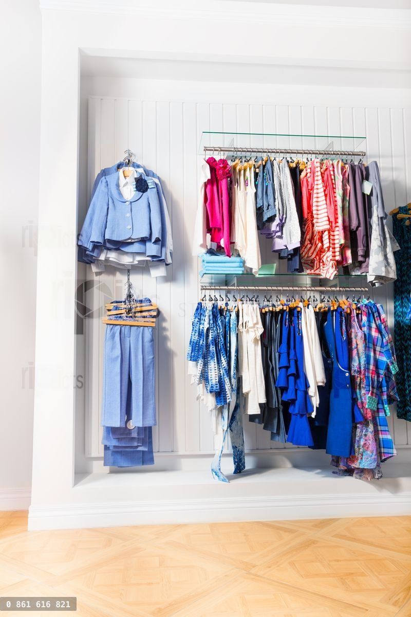 Many children clothes in store on white wall