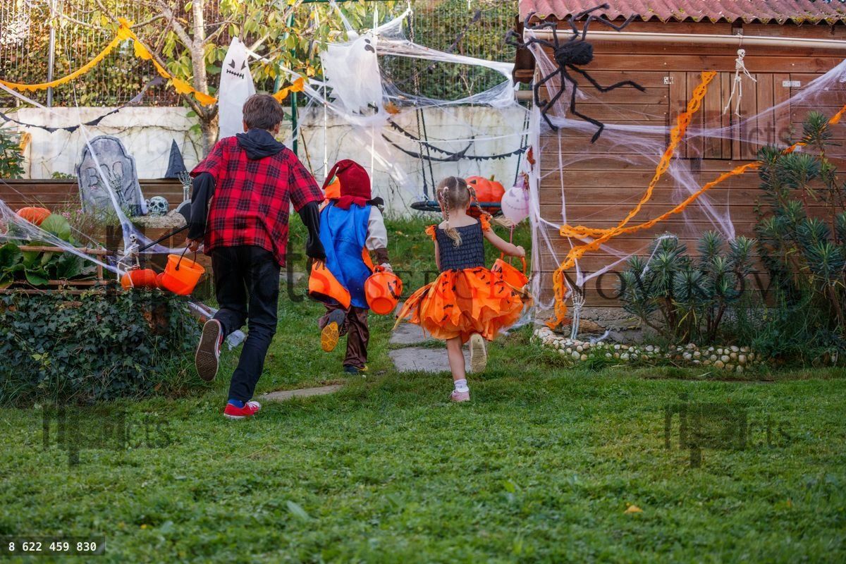 Children race through Halloween yard amid festive decorations