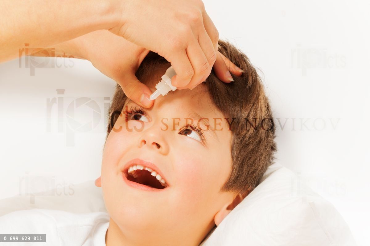 Woman helping kid boy to instill eye drops