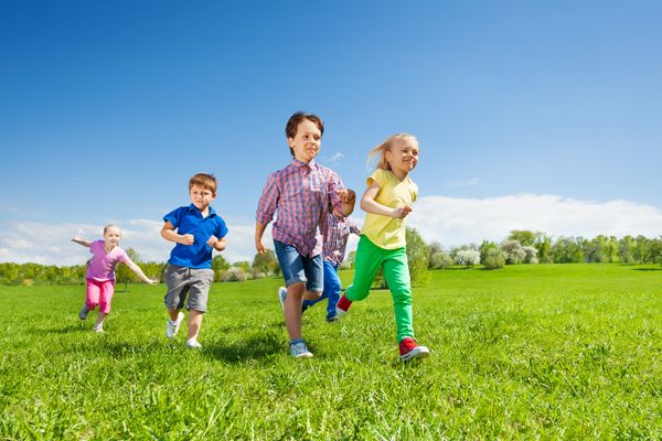 Happy group of children running in the green park