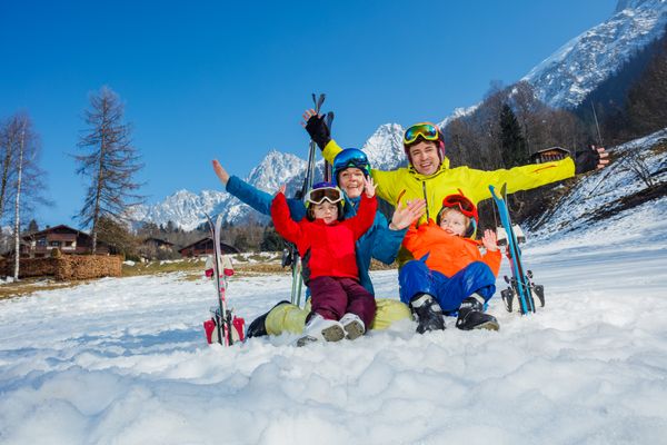 Happy ski vacation with kids dad and children cheer lift hands