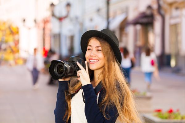 Beautiful young woman shooting with camera